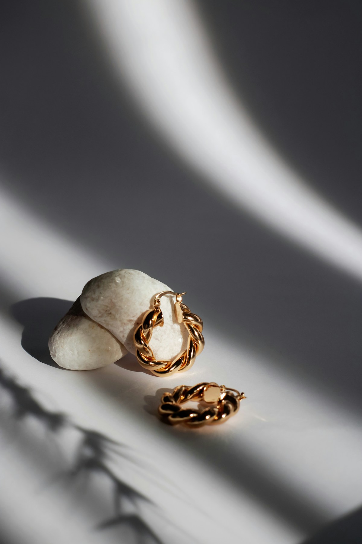 Gold-toned jewelry on a natural stone surface
